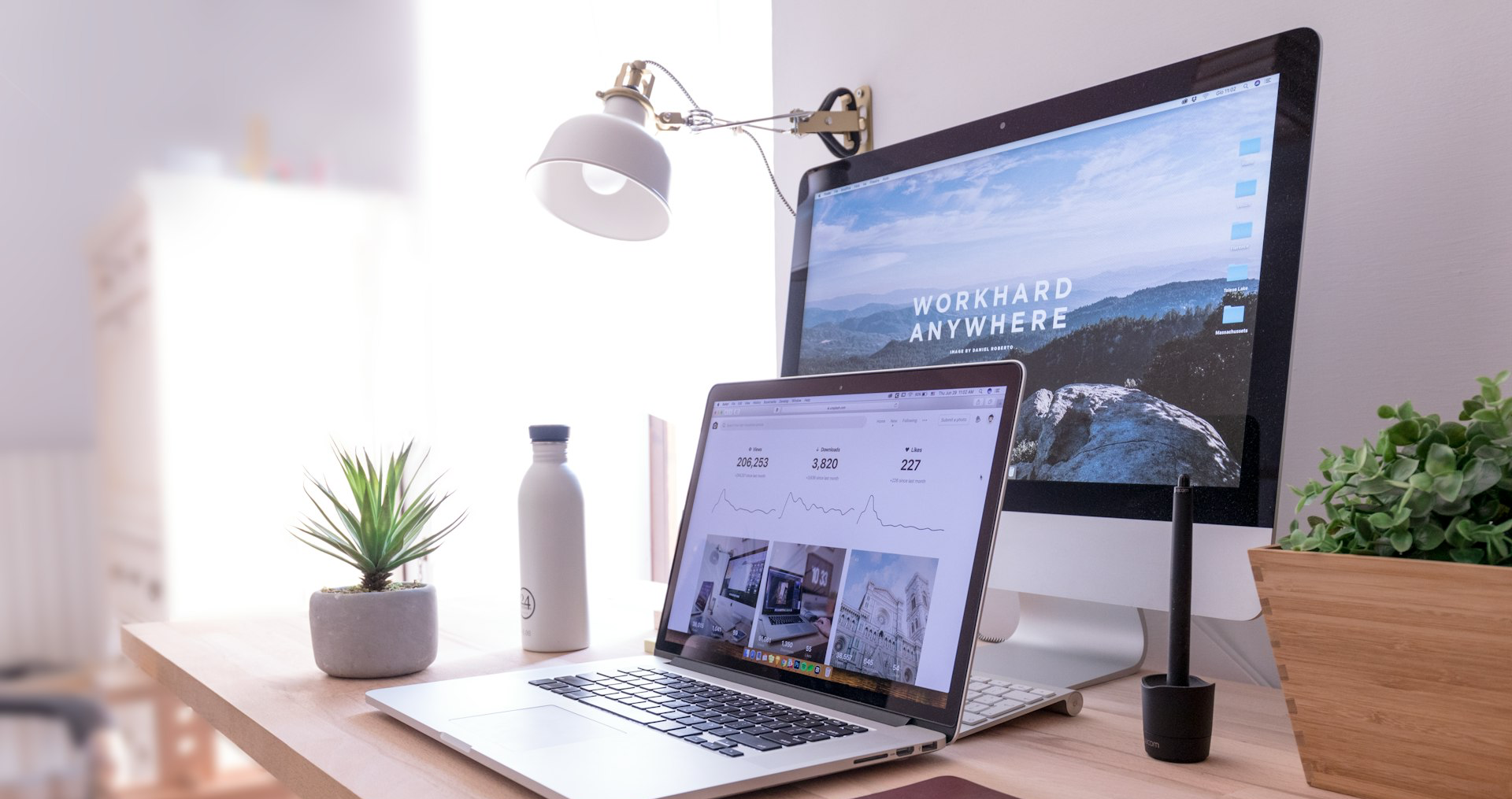 MacBook Pro on table beside white iMac and Magic Mouse